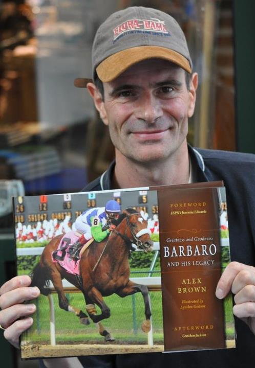 Alex Brown poses with his coffee table book Greatness and Goodness: Barbaro and his Legacy