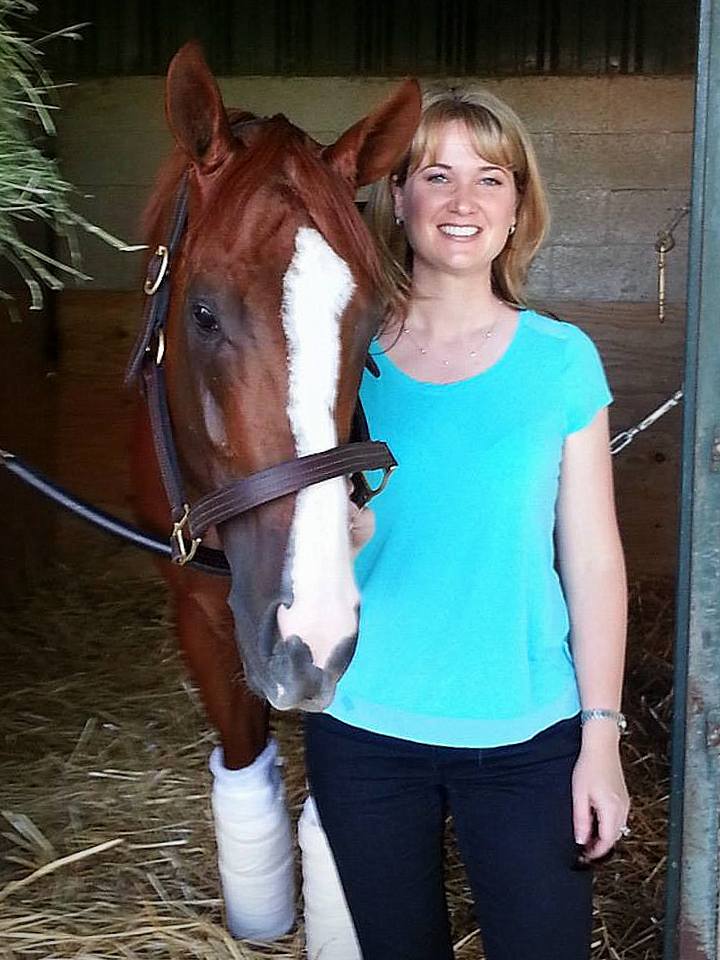 Kate Miller, Adoption Coordinator, CANTER Calif., poses with California Chrome in the halter.