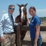 William Cox, chairman of the Thoroughbred Retirement Foundation's Second Chances program Wateree Correctional Facility joins TRF herd manager Sara Davenport at the fence line.