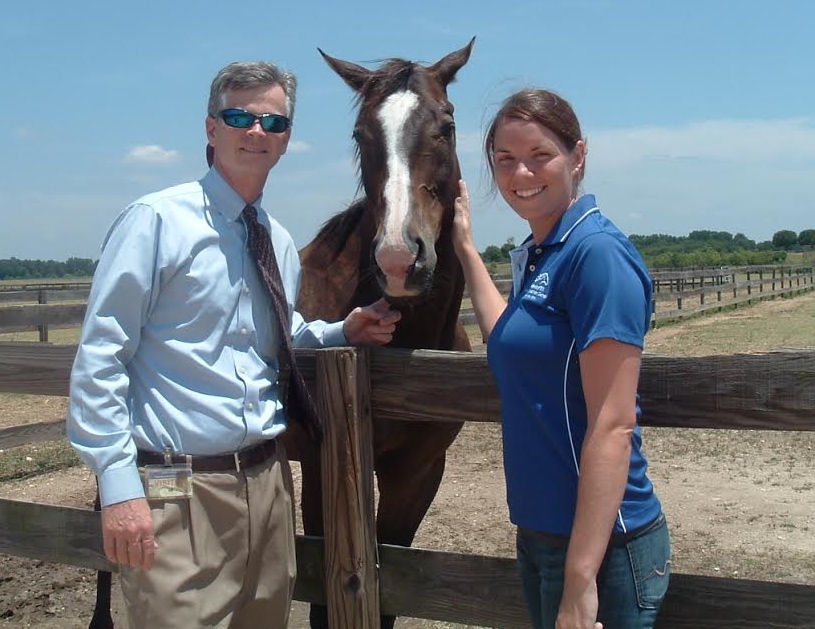 William Cox, chairman of the Thoroughbred Retirement Foundation's Second Chances program Wateree Correctional Facility joins TRF herd manager Sara Davenport at the fence line.