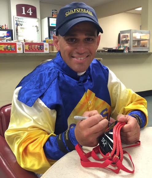 Hall of Fame jockey John Velazquez signs goggles to be raffled during Black Eyed Susan and Preakness stakes to raise funds for Thoroughbreds and permanently disabled jockeys.