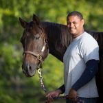 Tamio Holmes became a professional farrier after discovering a natural talent at the James River Work Center in Virginia. Pictured with Secretariat’s grandson, Covert Action. Debby Thomas Photography