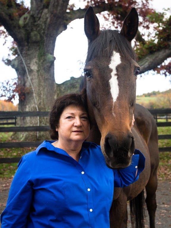 Susan Wagner, executive director of Equine Advocates poses with Press Exclusive, an OTTB and former broodmare who almost died shipping to slaughter. Equine Advocates is accredited by the TAA.